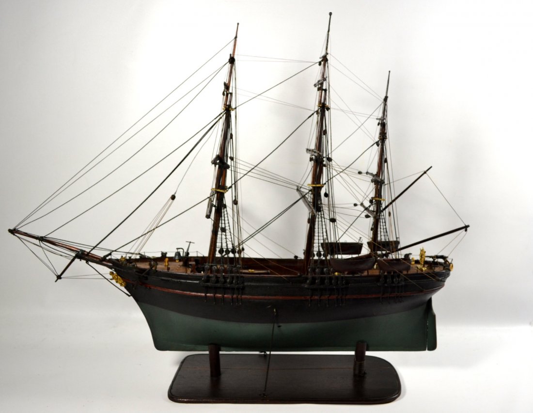 Ship Model, American Merchant Clipper, c. 1870: Ship model Material: Wood Description: Hand painted model of an American Merchant Clipper. It rests in a wooden cradle and is fastened with stays. Hull has old paint. There is a bone wheel, bone life 