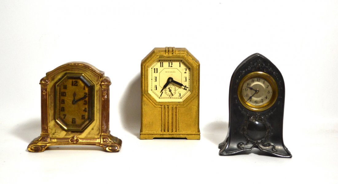 Clocks, 3 Small Shelf Clocks: 3 clocks Material: Metal Period: 20th Century Features: Three clocks. One Small New Haven German metal alarm clock painted gold (6"L x 2" W x 4" H) One small German metal clock with embedded decoratio