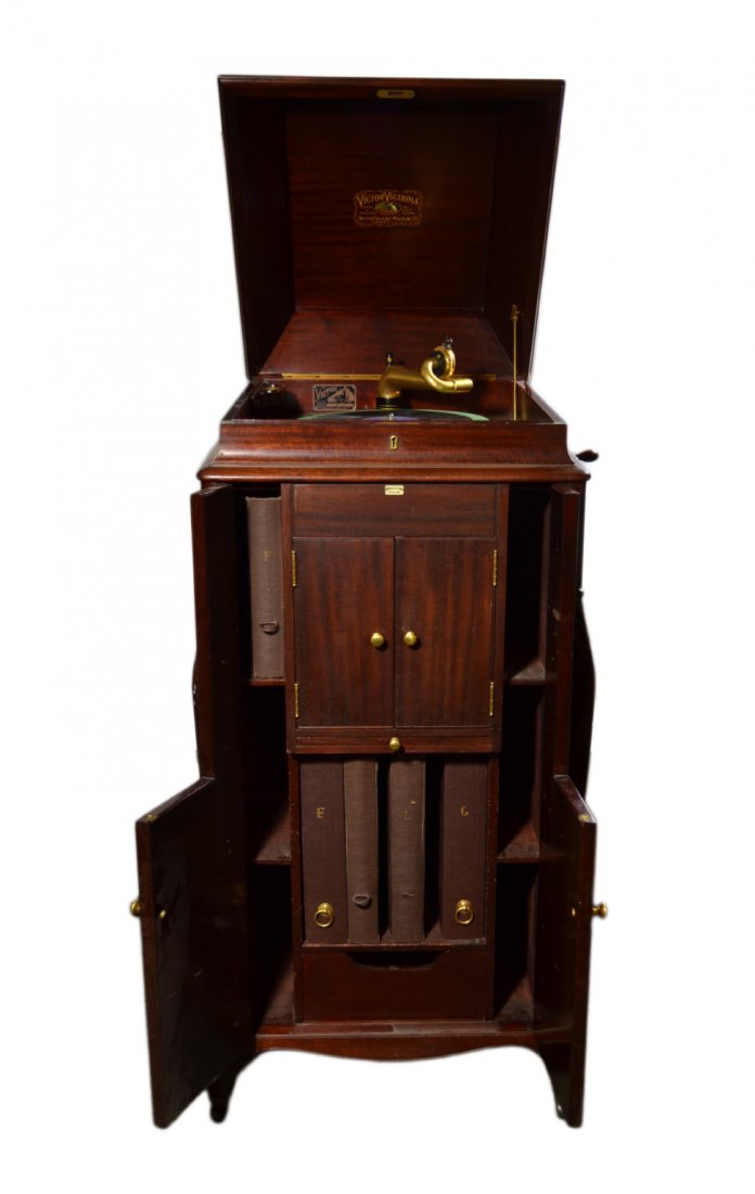 Phonograph, Victor Victrola, Model VVXVI, 1907: Victrola Phonograph Material: Mahogany Marks: (See Description) Description: The cabinet has a curved top section with "L" shaped storage doors and carved leaf decorations on the sides. Underneath the