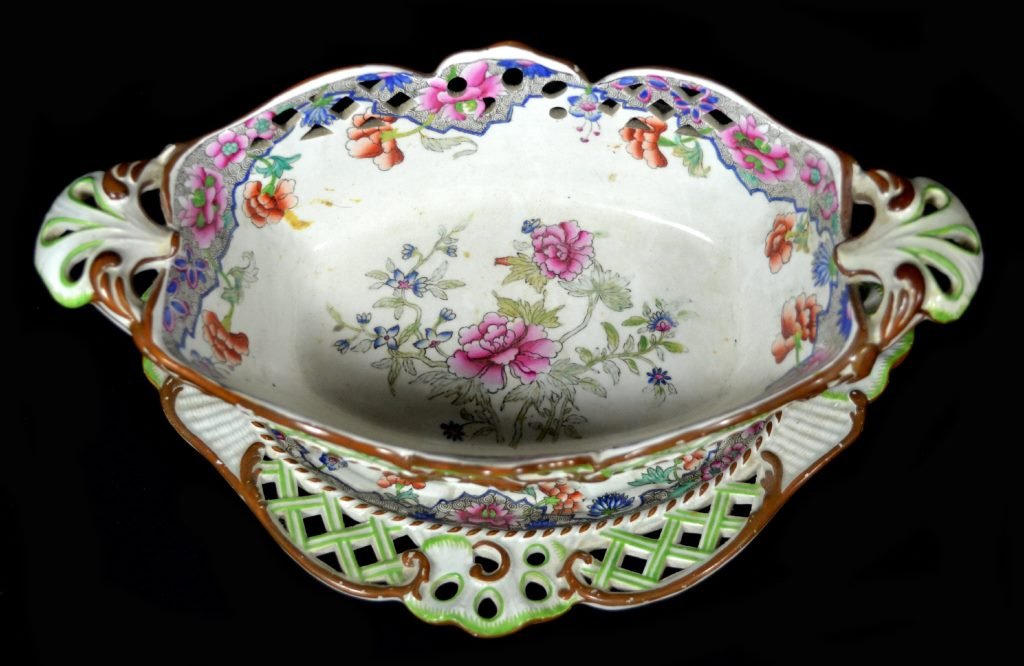 Sweetmeat Dish, w/ Under Plate, c. 1815-25: Form: Sweetmeat Dish Components: Hard Paste Decoration: Flower pattern decoration throughout piece. Reticulated Spode with matching under plate. Colors: White, Blure, Bown, Green Date: c. 1815-25 Prov