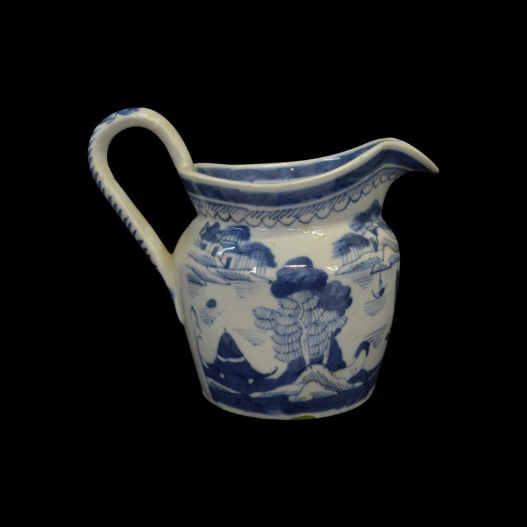 Pitcher, Canton, Chinese Export, C. 1840: Form: Pitcher Components: Hard Paste Decoration: Scenery depicts distant mountains, pagodas and other figures using the blue willow pattern. Colors: White, Blue Date: c. 1840 Provenance: The estate of