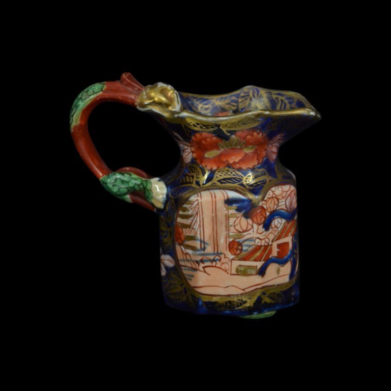 Jug, Miniature, Mason Ironstone, C. 1820: Form: Jug Components: Hard Paste Decoration: Floral pattern, hand painted, gilded and glazed. Handle is shaped in dragon form. Colors: Blue, Red, Green, Gold Markings: Mason Ironstone Date: c. 1820 Pr