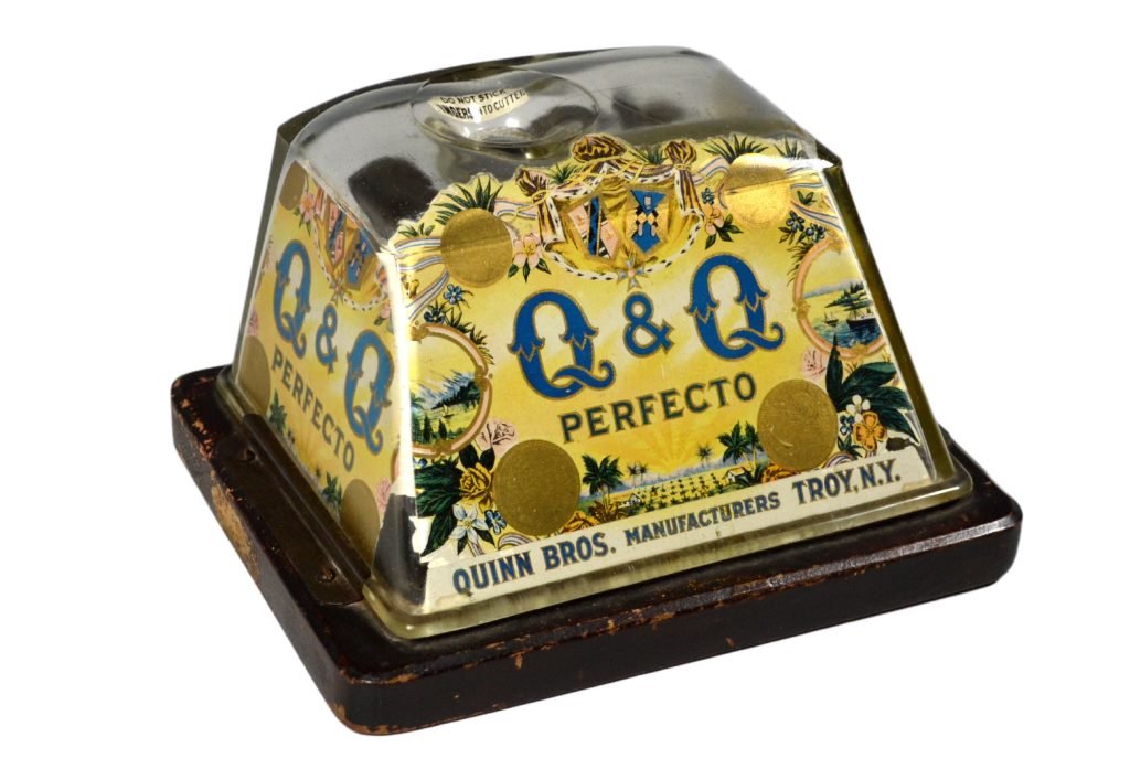 Cigar Plug Cutter Key Wind.c. 1900: Cigar Cutter Maker: Quinn Bros. Manufacturers Materials: Wood, Glass, Metal Marks: Innoinn ATL, Ohio Age: c. 1900 Description: Reverse decorated glass cigar cutter with wind up cutting mechanism. Mark