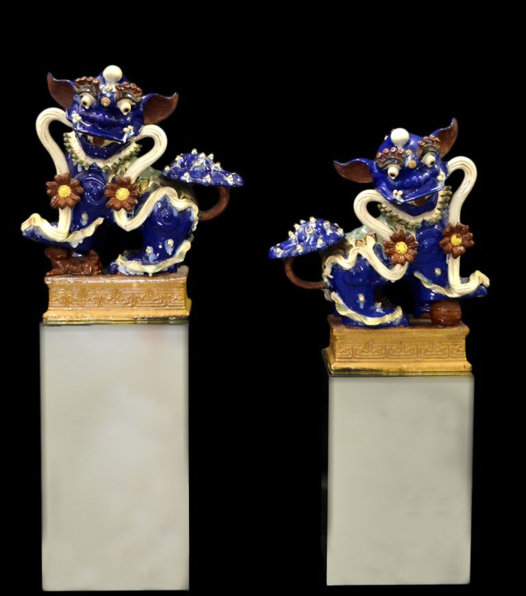 Pair of Large Foo Dogs on Mirrored Bases, 60"H: Pair of foo dogs Material: Ceramic Construction: Cast and modeled Marks: None Colors: blue, red, yellow, brown, green Description: A pair of foo dogs on mirrored bases. Ceramic in multi-color glazes o