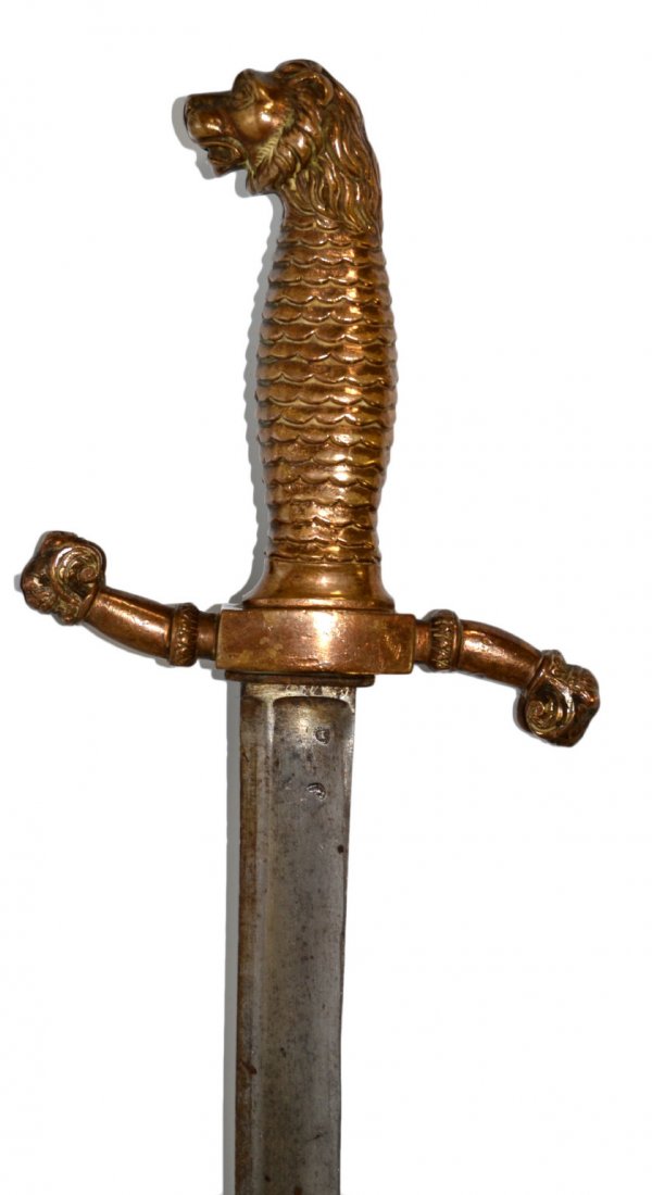 Sword, Brass Lions Head Pommel, c. 1810: Sword Material: Brass and steel Construction: Forged Marks: Manufact red. ... Features: Solid brass grip with lions head pommel and cross guards terminating in lion's heads as well. Wedge shaped bled