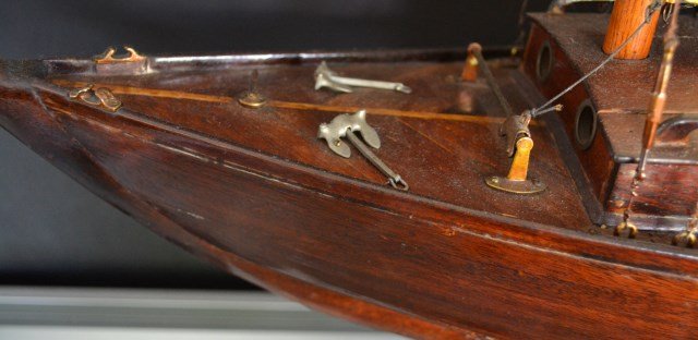 Pond model yacht, c. 1930, original sails: Pond Model Material: Mahogany planks/brass/silk Description: Pond model of a sloop yacht with a deck cabin,mahogany planked deck, hull and bottom. Lead keel, brass & lead fittings, original suit of sa