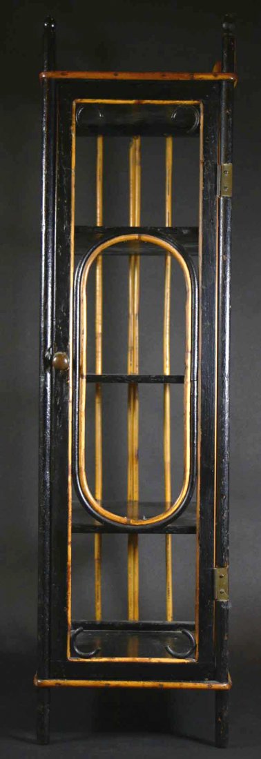 Stand, Rattan, Ebonized Wood Shelves, c1920: Description: A rattan stand, c. 1920. Ebonized wood shelf with pull on the door. Turned finials cap the posts. Material: Wood, rattan Maker/Artist: Unknown Date: c 1920 Provenance: Whitenack estate