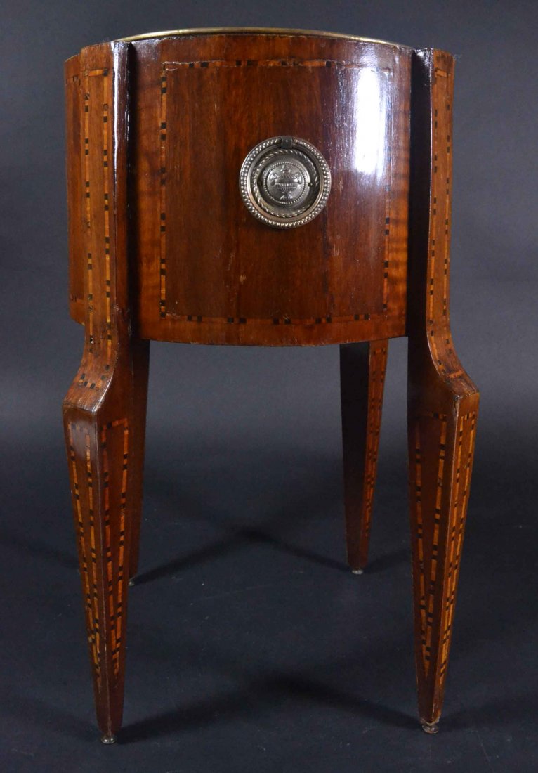 Planter, Mahogany, Banding Inlays, Brass c. 1810: Description: Planter, constructed of mahogany solids with oak secondary wood. Staved sections form the curve, with each leg an integrated stave at the top. Inlays of lyres on both front & rear, handle
