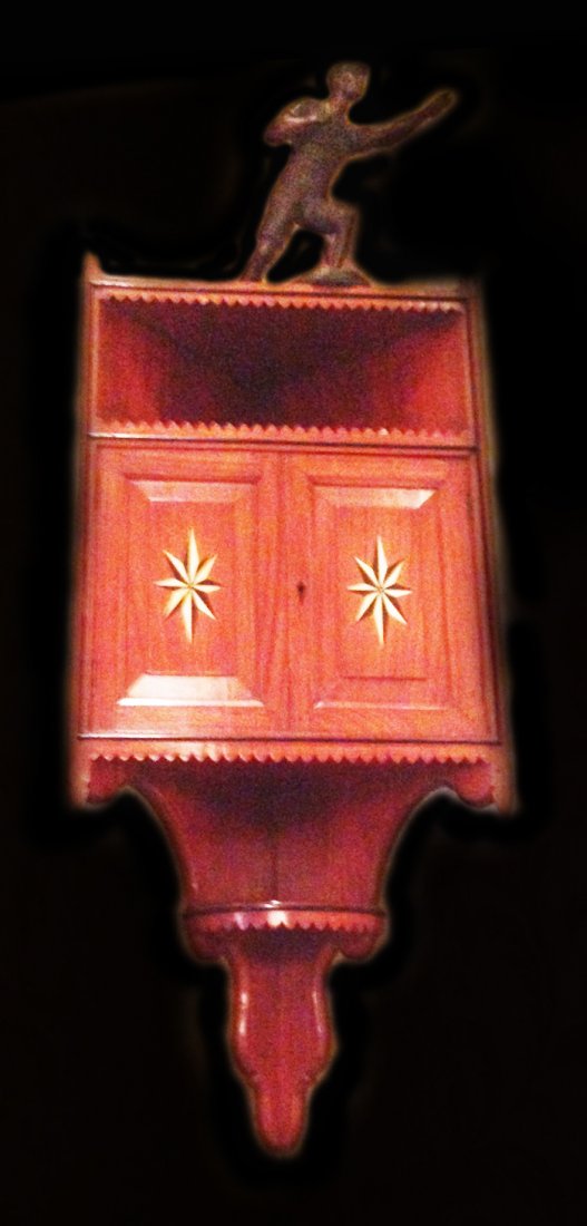Corner shelf cabinet, mahogany, bone, ebony: Description: Raised panel doors with compass rose inlays and applied moldings. Mahogany solids with ebony trim, circa 1770. Material: Mahogany, ebony Maker/Artist: Unknown Date: Circa 1770 Provenance: