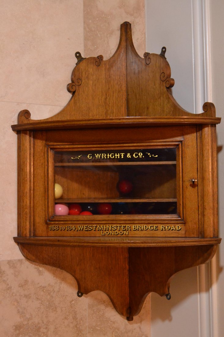 Billiard ball keeper, c. 1880: Description: Constructed of oak solids and formed as a corner shelf with a glazed door having reverse glass painted label of "G. Wright & Co." On the wood beneath, "158 to 164, Westminster Bridge Road