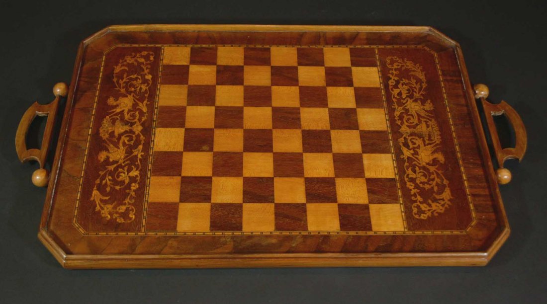 Gameboard/Serving tray, c.1890: Description: Swivel handles make this reversible game board flip to convert to a serving tray with marquetry and inlay designs. The board is made of mahogany, birch, rosewood and ebony. Tray side a wi