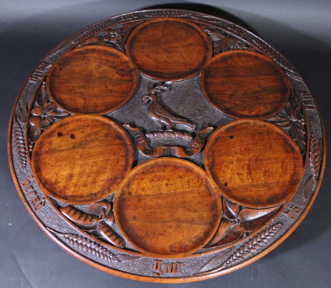 Lazy Susan, c. 1880: Description: Constructed of turned and carved walnut with iron plate screwed to the bottom of the tray. Center hub is drilled of lignum vitae to receive the wood post for rotation. Apron is carved in