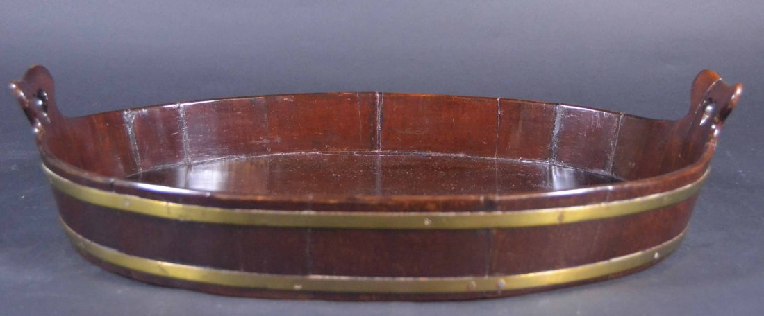 Serving tray, c.1840: Description: Constructed of mahogany in staves having brass binding. Bottom is one piece chamfered and mortised into the sides. Heart shaped cutouts. Material: Mahogany, Brass Maker/Artist: Unknown Da