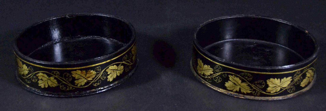 Wine Coasters Pr. Papier Mache, Blk Lacq., c1840: Description: Pair of papier mache wine bottle coasters, black lacquered with decoration of trailing vines in gilt. English, c 1840. Labels on the bottoms read 'Mrs. Kenneth Wilson' . Material: Papier