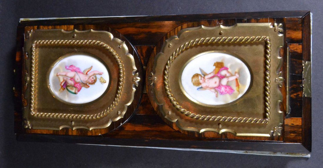 Bookslide, Macasar Ebony wood, dated (18)77: Description: Self closing; engraved: Pearce Cornhill and dated (1877). Brass hardware, porcelain inserts, satinwood bottom, Cherubs. Engraved on brass hardware: Betjemann's (sic) Patent. Material: Cor