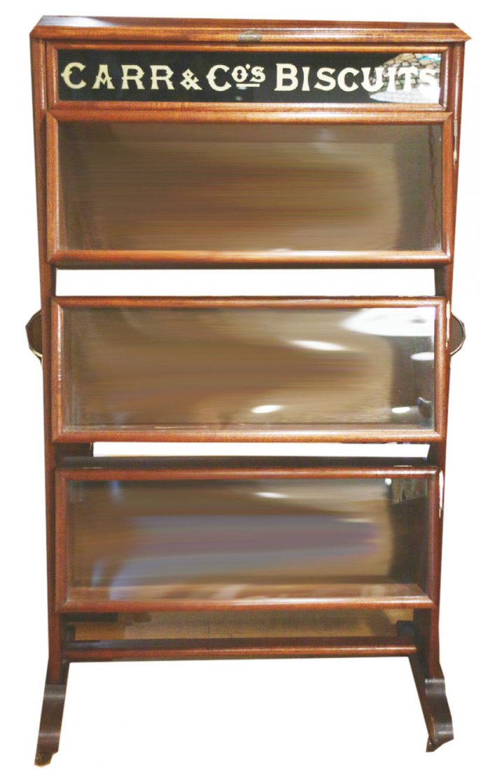 Cabinet, Advertising Carr & Co. Biscuit, Mahogany: Description: A mahogany display cabinet advertising Carr & Co biscuits. Cabinet has 3 glass lift style doors with a locking hardware to remain open. The advertisement for the biscuit company is done i
