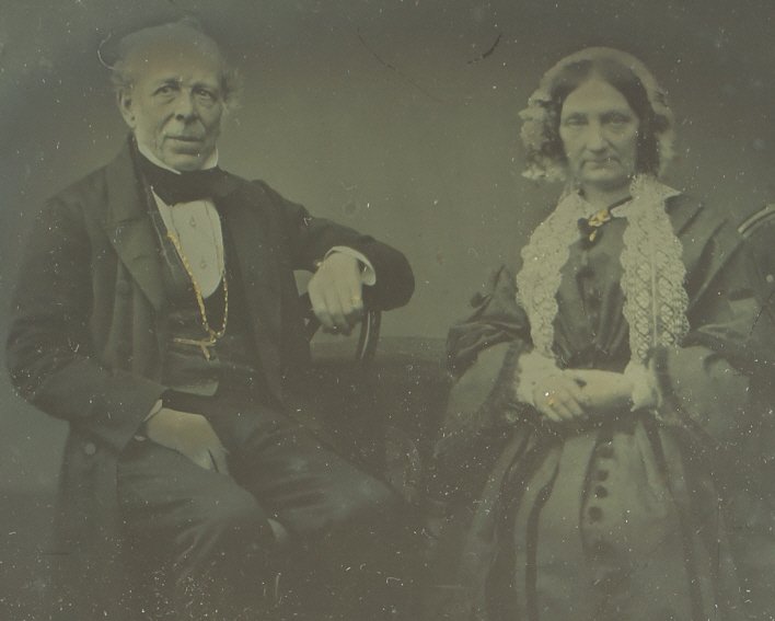 1/4 plate ambrotype: Description: Plate Size: 1/4 platePhoto type: AmbrotypePhotographer: Unknown Hand Coloration: Forehead and accessories/giltSubject Matter: Older couple seatedCase Name: Floral Scroll ThemeCase Type/Ma