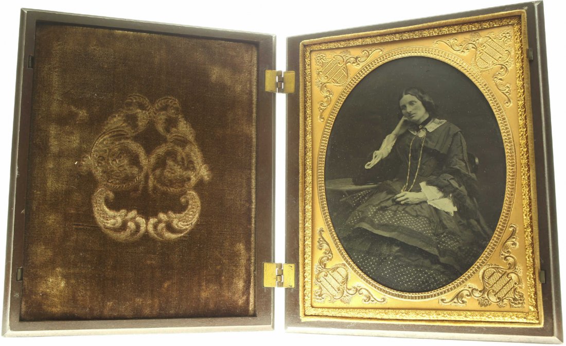 plate ambrotype: Description: Plate Size: ½ platePhoto type: AmbrotypePhotographer: Unknown Hand Coloration: Accessories/giltSubject Matter: Woman seatedCase Name: Oval with patternCase Type/Maker: A. P. Critchlow & 
