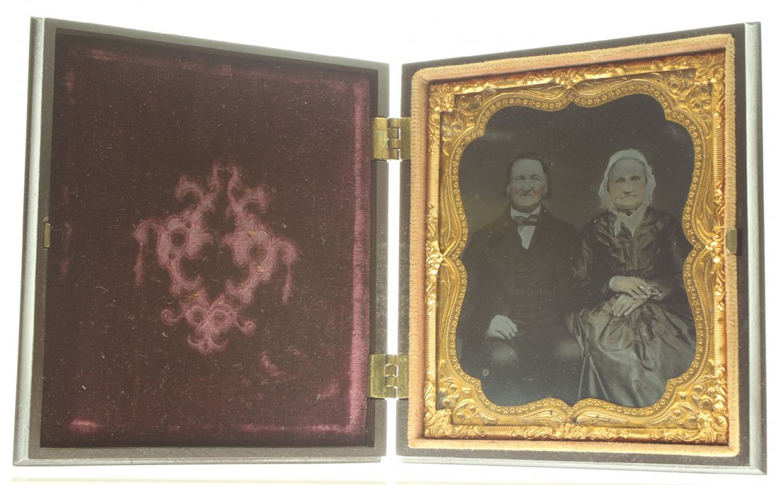 1/6 plate ambrotype: Description: Plate Size: 1/6 platePhoto type: AmbrotypePhotographer: Unknown Hand Coloration: Cheeks and accessories/giltSubject Matter: Elderly couple seatedCase Name: Lily Scroll MotifCase Type/Make