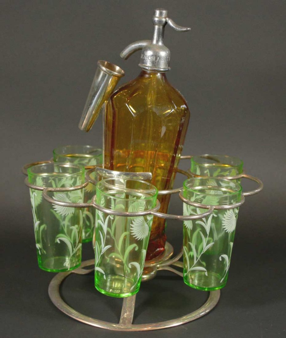 Tumblers and Coca Cola Seltzer bottle, circa 1940: Description: 6 tumblers and a Coca-Cola Bottling Co seltzer bottle with carrier.6 clear green glass tumbles with white flowers on them 1 amber seltzer bottle with the Coca-Cola Bottling Co engraved on