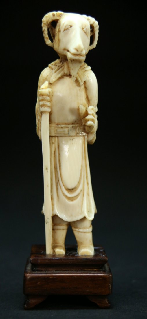 Ivory, Standing Ram, Chinese mid-20th C: Description: A carved ivory standing ram figurine, the ram is wearing robes and holding a cane, has a rosewood base. Material: Ivory Maker/Artist: Chinese school Date: Mid 20th century Provenance: P