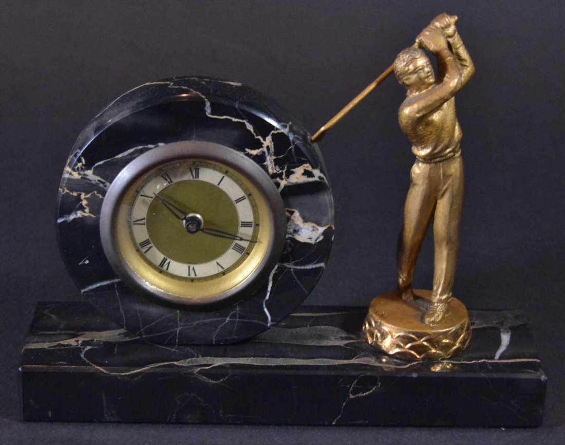 Golf Clock, Marble, Bronze Golfer, C. 1920: Antique and Collectables Category: Sports Description: A black marble with a golf theme table clock. The face of the clock has black roman numbers and black hour and minute hands, the background of th