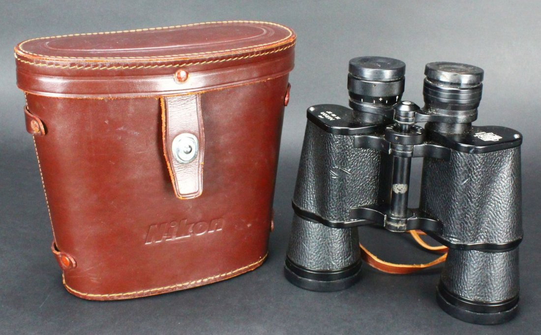 Binoculars, Nikon, Vietnam War era, w/ Case: Antique and Collectables Category: Optical Description: These binoculars are made of black plastic with rubber lens protectors. The case is brown, stitched leather with a steel clasp to hold the cover