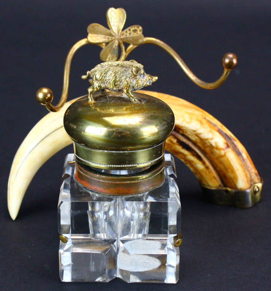 Inkwell, Boar's Tooth: Description: A boar's tusk mounted on a brass glass inkwell. Above the tusk is a brass three leafed clover and a horizontal pen holder. A brass boar is sculpted in brass atop the inkwell holder. Histo