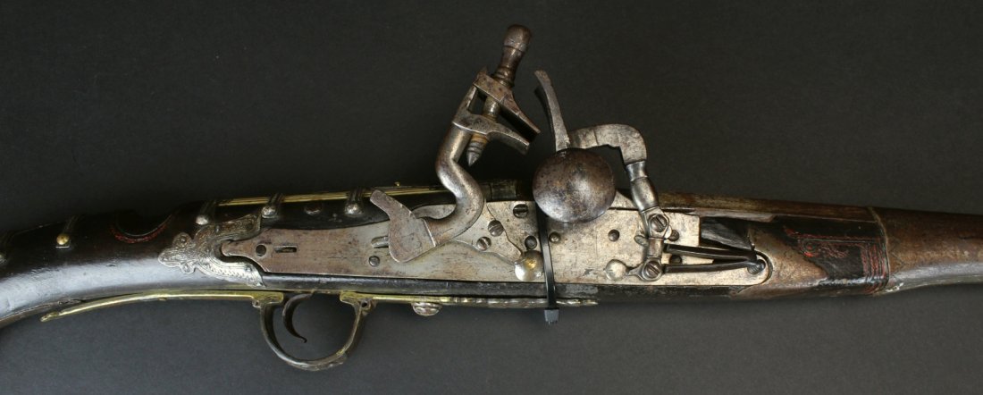 Flintlock, Sterling, Ivory 18th C: Description: A 20 bore North African Snaphaunce gun. Morocco, 19th c. with tapering sighted barrel molded at the muzzle and retained by eight chased silver bands. Lock of characteristic form, hardwood