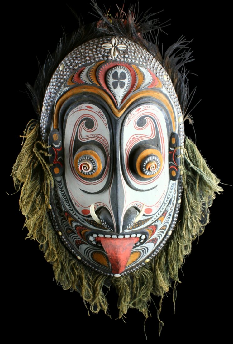 Aboriginal Mask, Papua New Guinea: Description: Ceremonial Mask of carved wood with polychrome paint decoration, boar's teeth, cowrie shells in two rows and psychedelic looking eyes made from volute shells cut in half. History: New Gui
