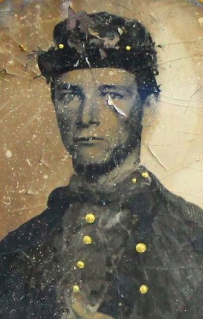 Tintype, Civil War, Ninth Plate: Description: There are some hand-applied colors in the form of gold buttons on the uniform of the soldier photographed. The soldier, a young man, is standing, shown from the waist up, with his hand ne