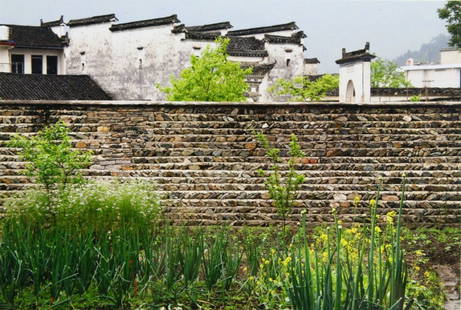 Photograph by Olivia Parker, China, 2003: Description: Print is housed in a faux bamboo frame depicting a stone wall with grasses and flowers in the foreground and tiled roofs in the background. History: After graduating from Wellesley Colleg