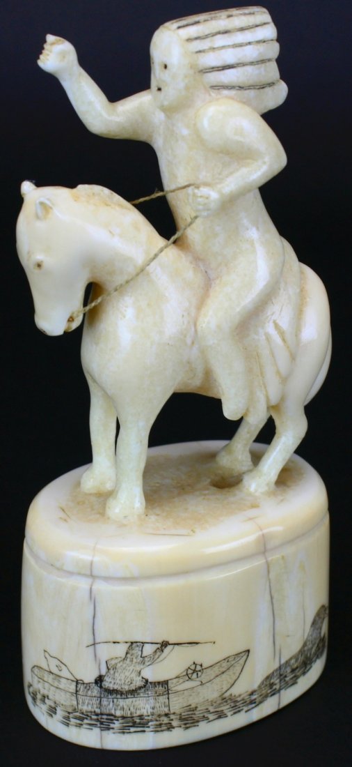 Unique Walrus Ivory Carving of Indian on Horse: Description: A one of a kind Eskimo carving of an Indian on a horse. He used a fruit box label as the model. Traditional Eskimo scrimshaw on the base depicts fishing and seals. History: Ivory statue i