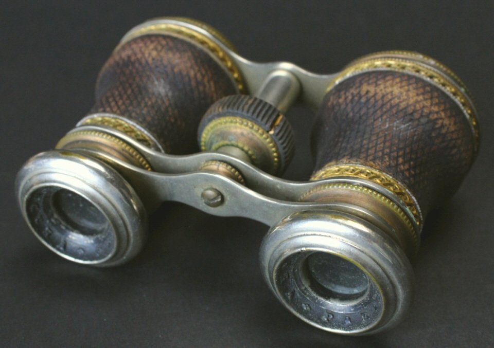 Brass and Leather, Vendome, Paris: Description: A pair of brass, nickel plated and enamel opera glasses. The barrels are covered in leather with brass scrollwork at top and bottom. Vendome, Paris is hallmarked on black painted surface 