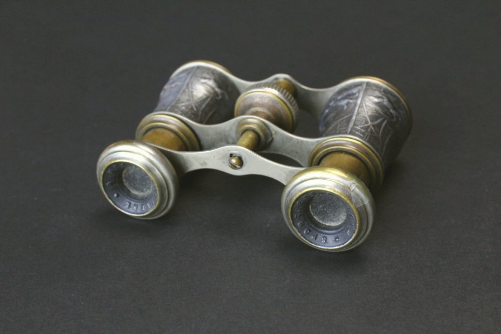 Brass Hunting Scene, Sportiere, Paris: Description: A pair of brass and nickel plated opera glasses. There is a hunting scene of deer and dogs decorating the barrels. Hallmarked on the eye pieces is "Sportiere, Paris. History: Opera glasse