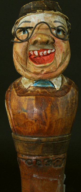 Cane, Bamboo, Laughing Man, C. 1900: This cane or walking stick is made almost entirely of bamboo with a carved soft wood bust as a grip. The bust depicts a man laughing with an exaggerated guffaw, his entire top row of teeth visible. A