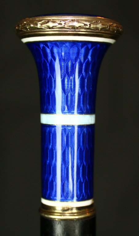 Cane, Guilloche Enamel, Sterling, C. 1890: The dark rosewood of the shaft of this cane or walking stick comes to a thin sterling collar up from a horn ferrule. The head of the cane is a deep blue guilloche enamel banded with a while bubbled de