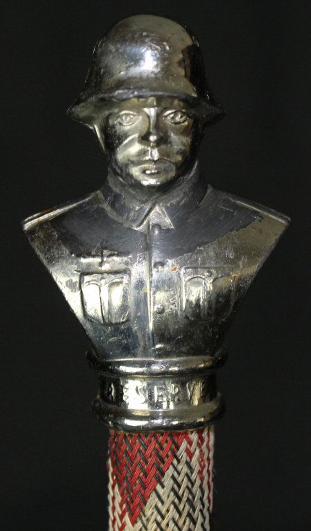 Cane, Nazi German Enlisted, WWII: This enlisted man's swagger stick cane or walking stick is entirely covered in a chevron patterned, tight knit fabric in green, cream, and red. A double headed tassel trails from beneath the topper. T