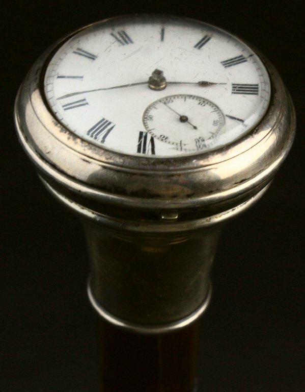 Civil War Era Gadget Cane, Watch Head, 1862: Civil War era ebony cane or walking stick has a silver collar leading to a sterling watch case containing a pocket watch. The case is hinged, opening to release the pocket watch as necessary. Watch is