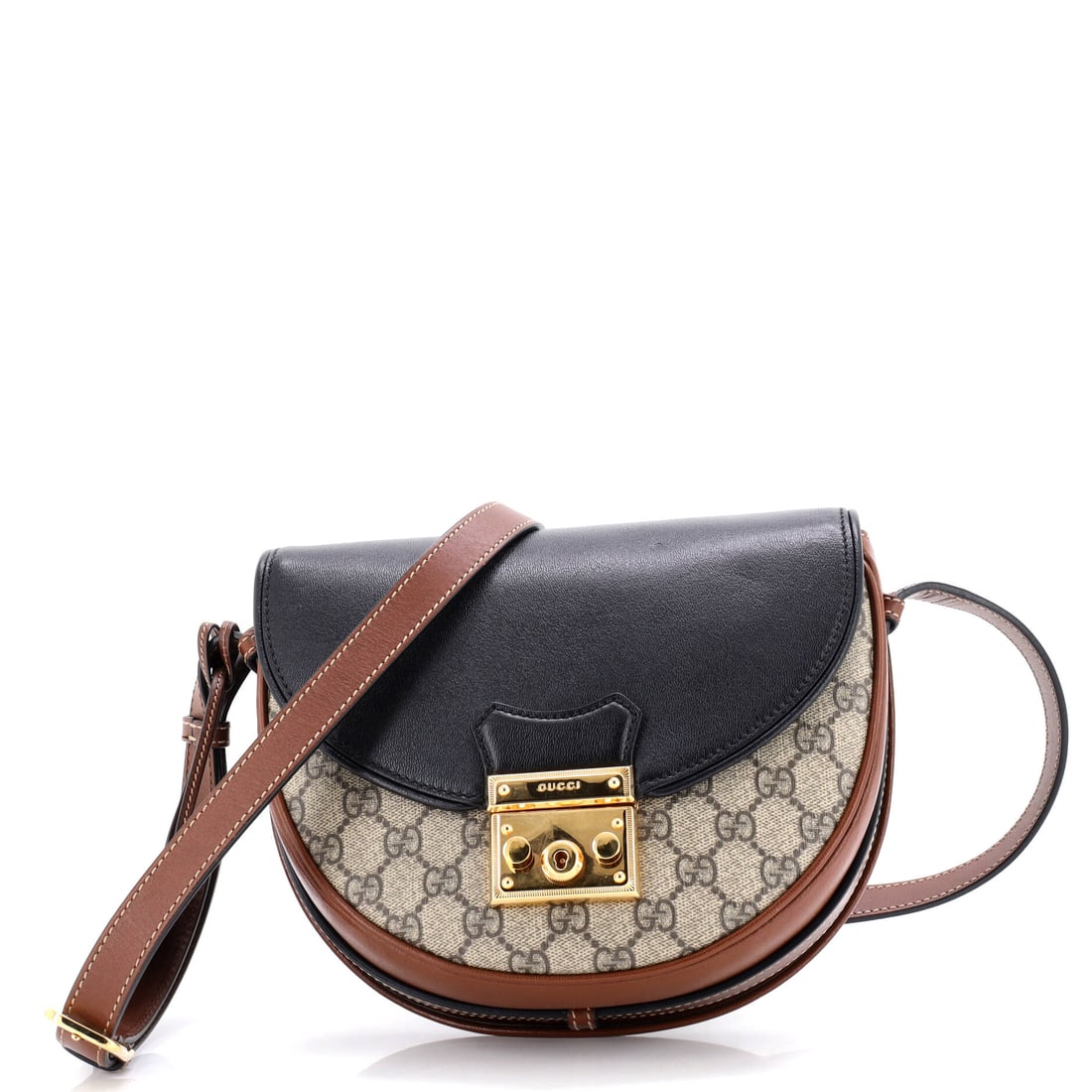 Gucci Padlock Saddle Shoulder Bag GG Coated Canvas and Leather: Gucci's Padlock arrives in the architecture that made the line known: the flap silhouette closed by the padlock-and-key hardware that names it. It carries GG canvas - the coated cotton jacquard Gucci 