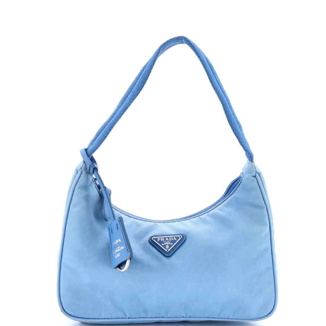 Prada Re-Edition 2000 Hobo Tessuto Mini: Prada's Re-Edition 2000 Hobo sits squarely in the maison's most-quoted handbag language, with a profile that has earned its place in serious wardrobes. It is finished in tessuto, Prada's signature tec