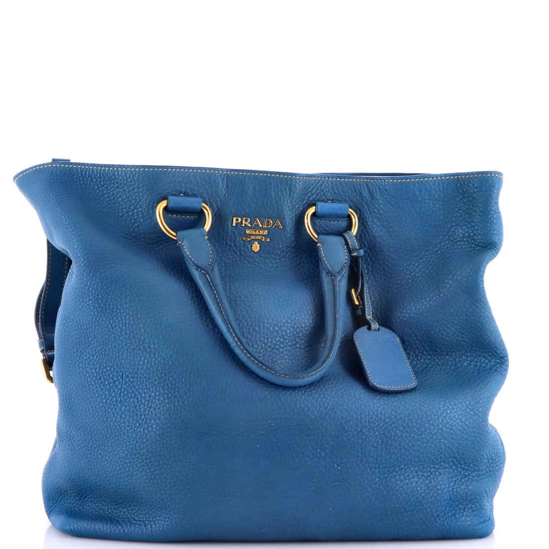 Prada Convertible Shopper Tote Vitello Daino Large: The Prada Convertible Shopper Tote carries a stance the maison has refined across many iterations into something instantly recognizable. Worked in Vitello Daino, the surface carries a measured, well-b