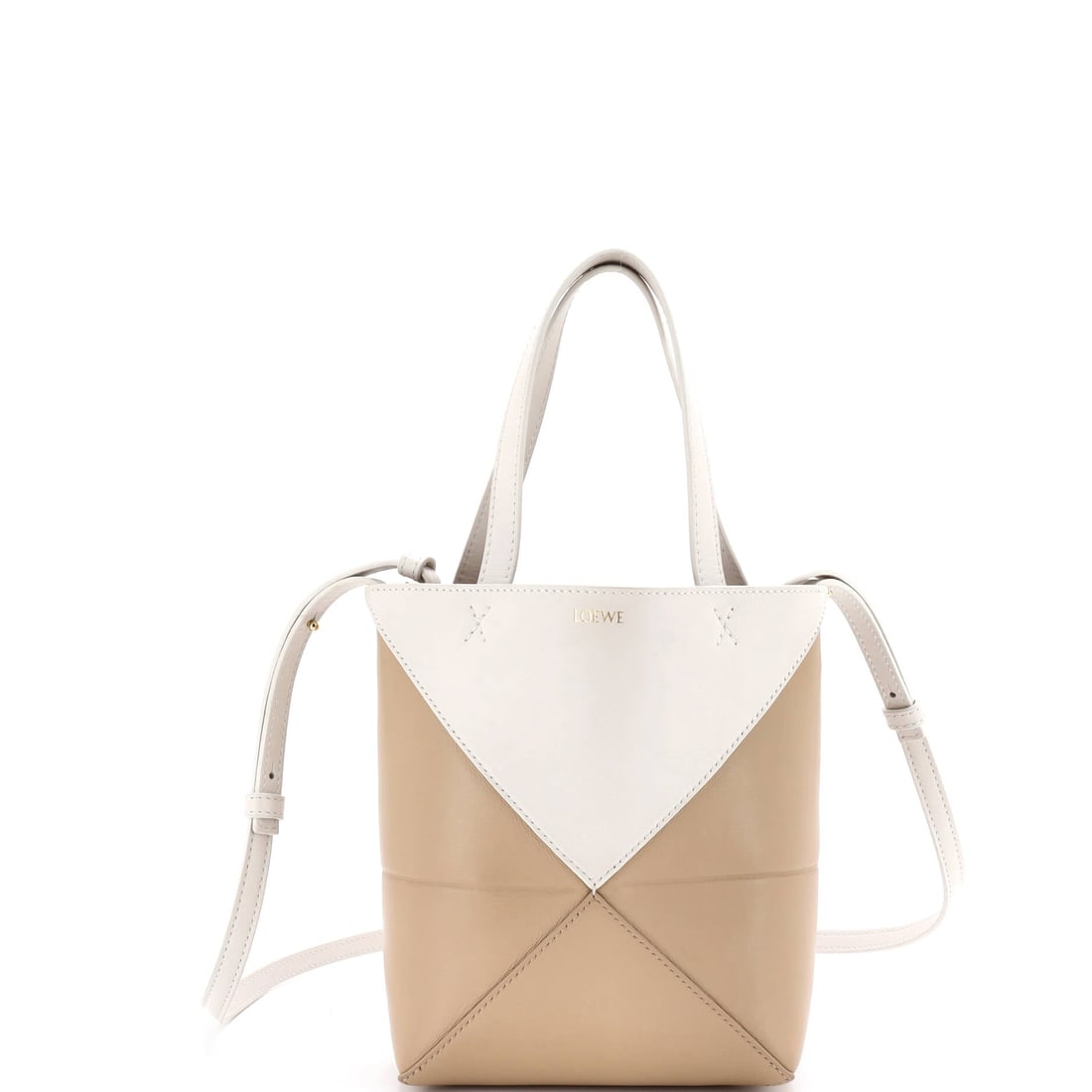 Loewe Puzzle Fold Tote Leather Mini: Open the Loewe Puzzle Fold Tote and the pocketing is the first thing you notice, the kind of interior that takes structure seriously. Cast in a saturated neutral, the kind of palette that earns a seco