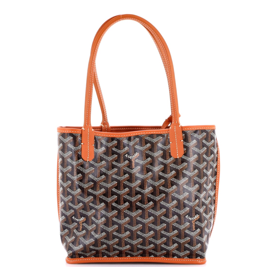 Goyard Anjou Reversible Tote Coated Canvas Mini: At the surface, the Goyard Anjou Reversible Tote relies on the house's coated canvas, a waterproofed jute and cotton famous for its quiet chevron, the leather choice doing the work of the design. The 