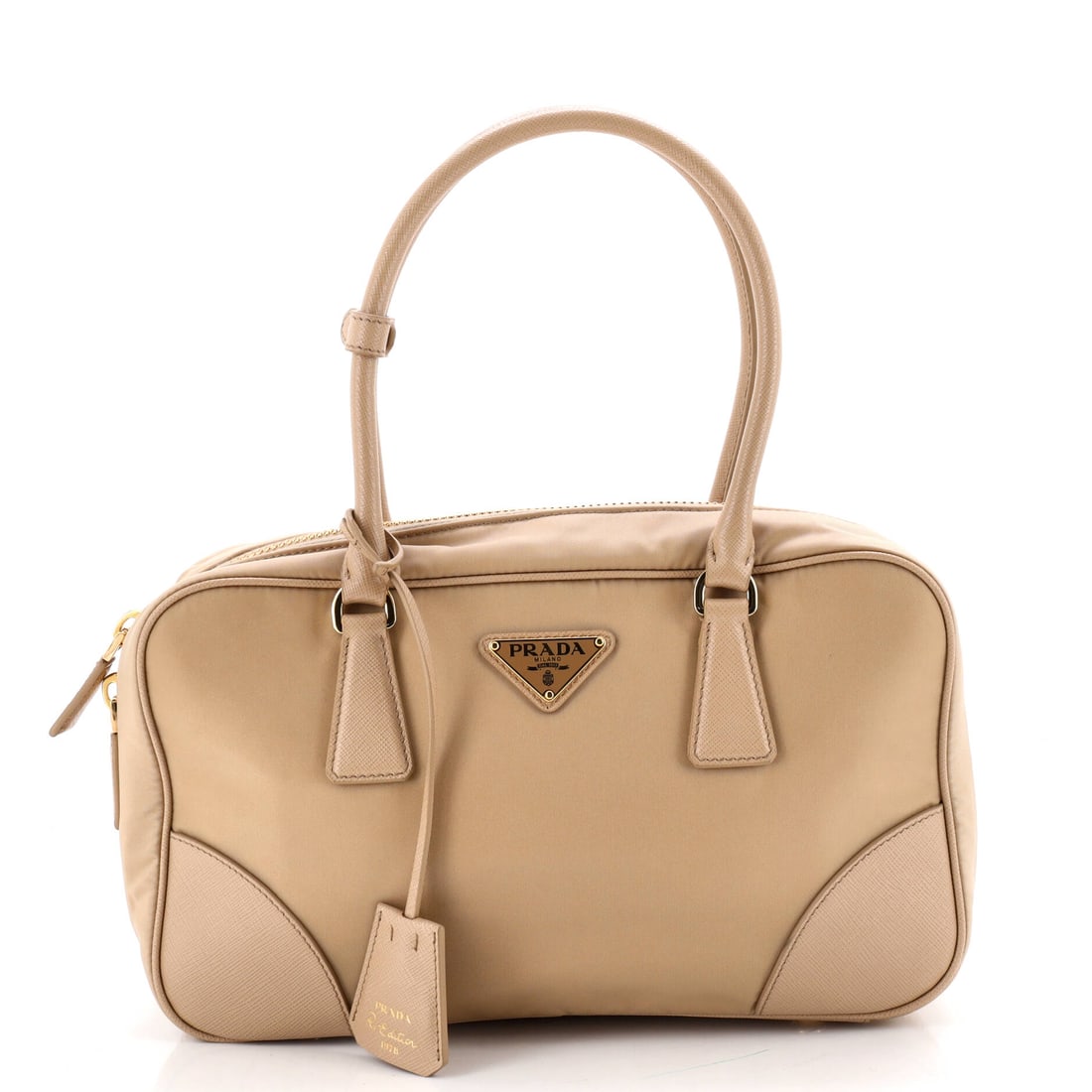 Prada Re-Edition 1978 Bauletto Bag Re-Nylon with Saffiano Leather Medium Neutral: From Prada, the Re-Edition 1978 Bauletto Bag Re-Nylon in neutral Saffiano leather. It is presented in the Medium size. The silhouette reads clearly across the room, giving it strong presence as a bidd