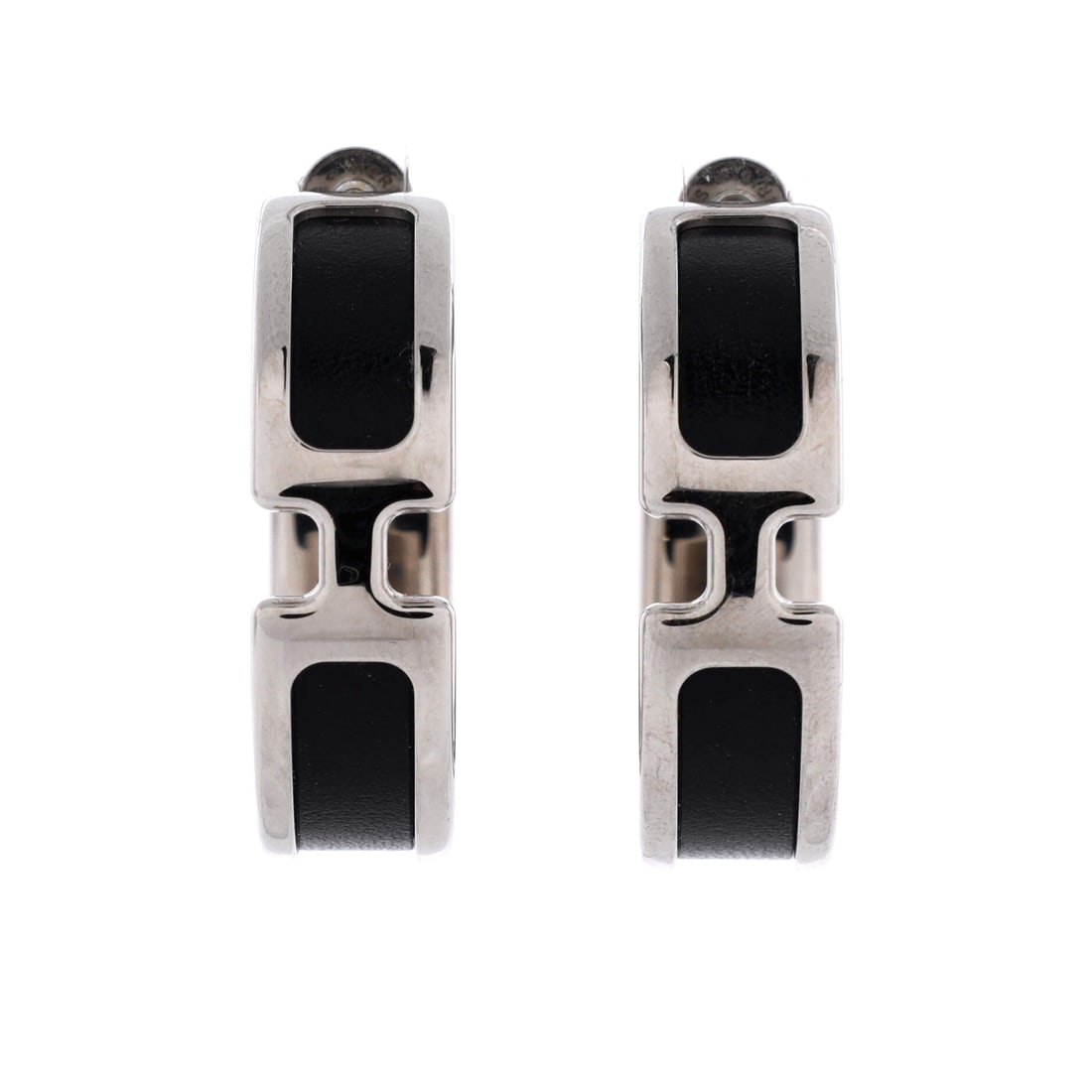 Hermes Olympe Hoop Earrings Metal and Leather: Olympe hoops pair metal with leather, the two materials sharing the curve so the hoop changes surface as it turns. At 1.35 in long and 0.4 in wide they sit at mid-size, visible past a collar and easy 