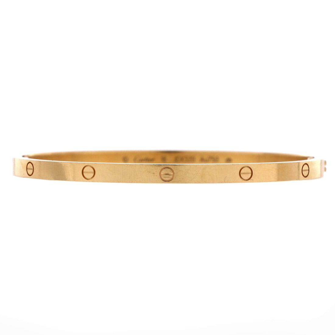 Cartier Love Bracelet 18K Yellow Gold: Screwed shut across two halves, this yellow gold Love bangle keeps the small model's 3.6 mm width and the flat inner surface that makes it comfortable full time. Sized with a little slack, it shifts a