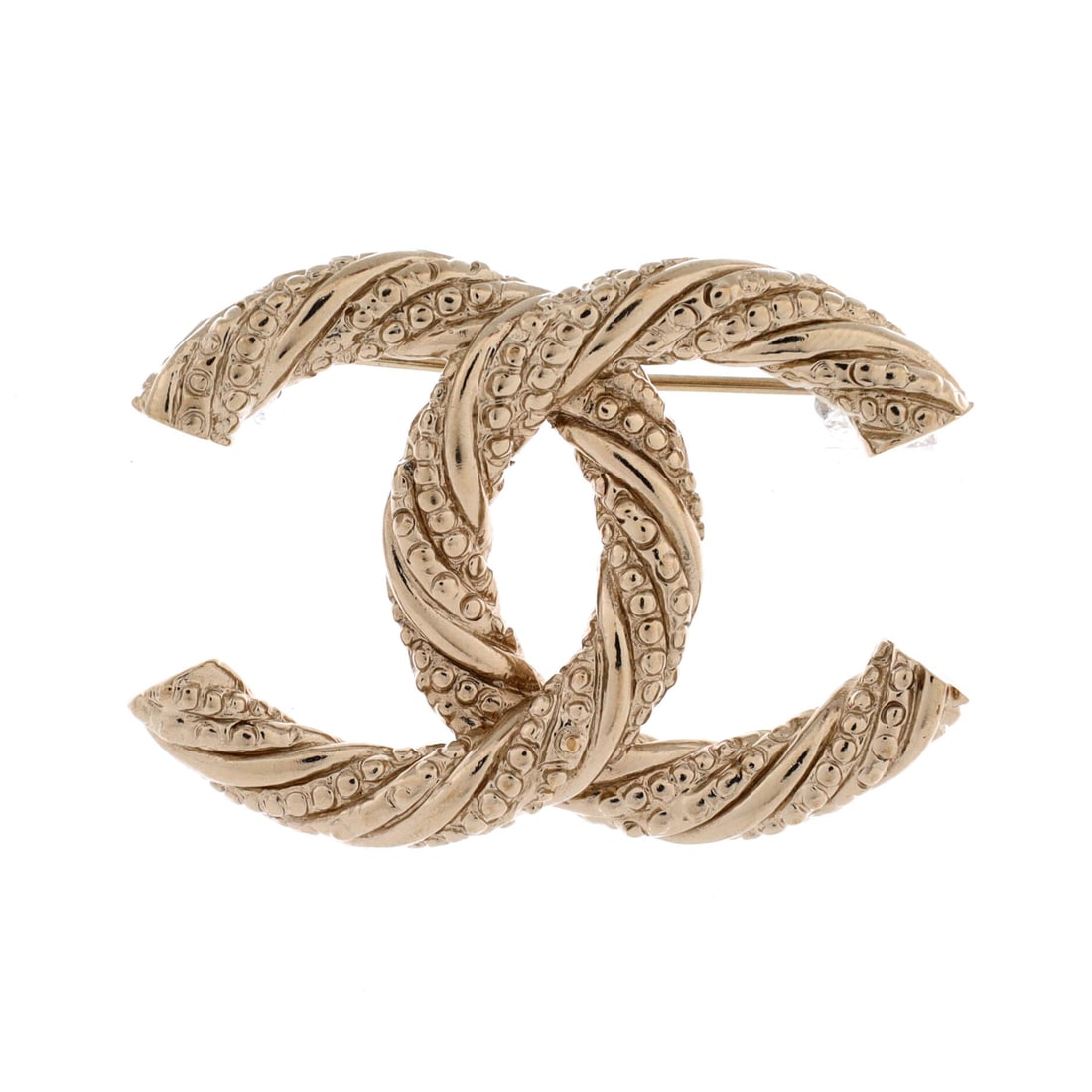 Chanel Twisted CC Brooch Metal: The twist is the whole argument for this brooch: the two Cs are turned out of plane so the interlock catches light from several angles at once, which the flat version simply cannot do. Metal throughou