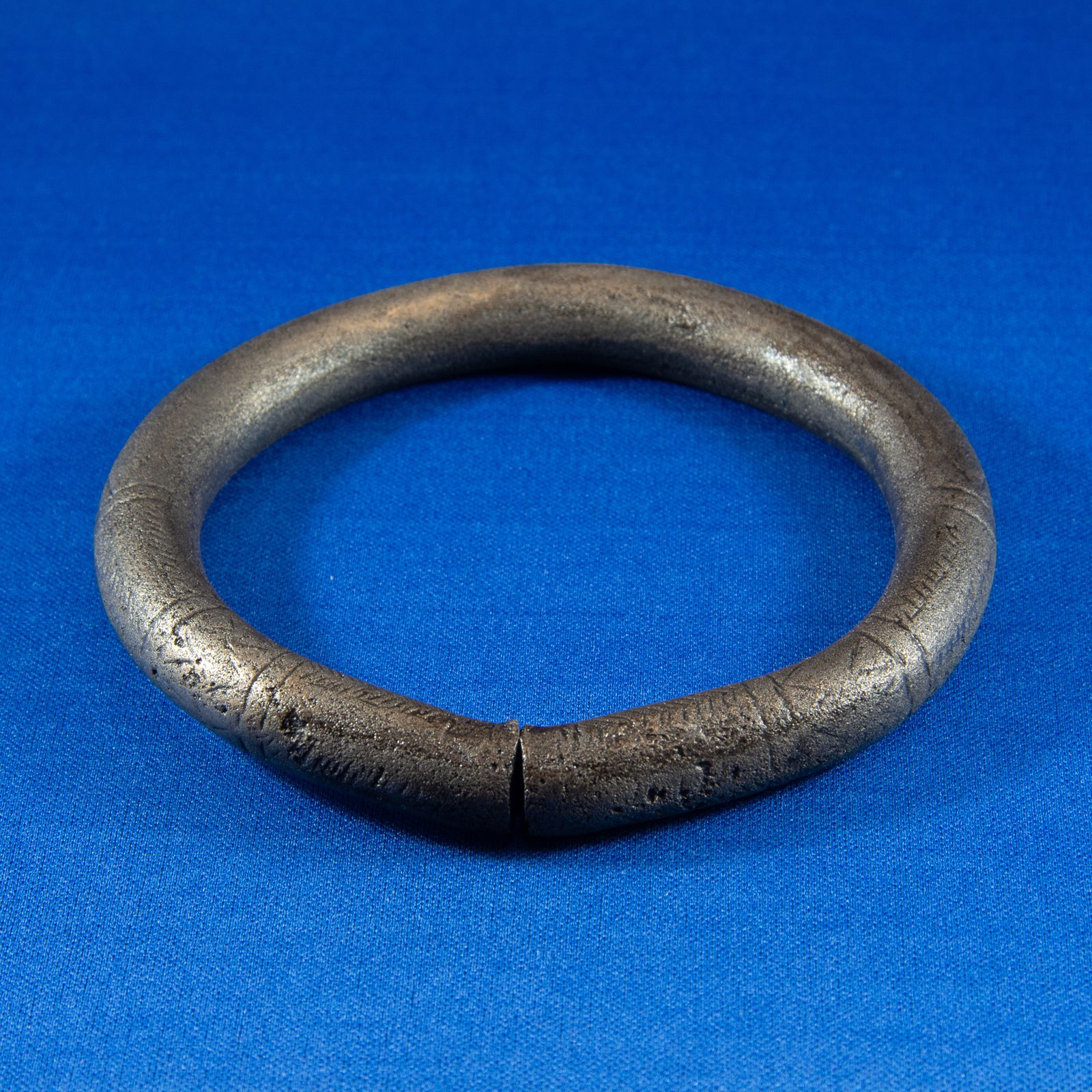 ANKLET: GEOMETRIC LURISTAN (1000-500 BC): A Luristan bronze anklet made from a thick, heavy cast bronze ring formed into a nearly closed circular hoop with a narrow opening. The piece has a substantial round-section profile characteristic of