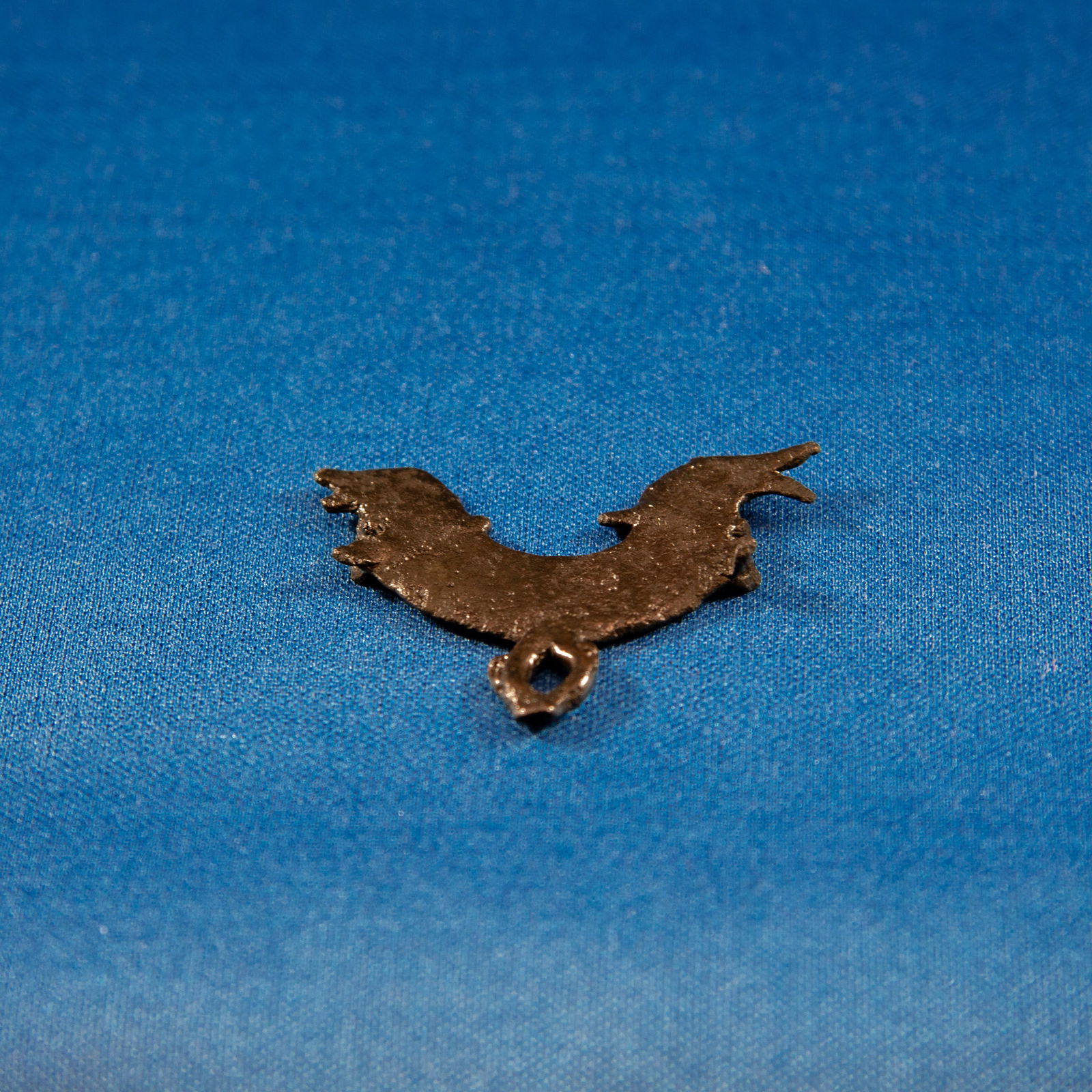 FITTING: ZOOMORPHIC LURISTAN (1000-500 BC): A compact Luristan bronze zoomorphic fitting, cast in the form of two opposing animal heads emerging from a single crescent-shaped body. Each head is modelled with short snouts, raised ears or horns,